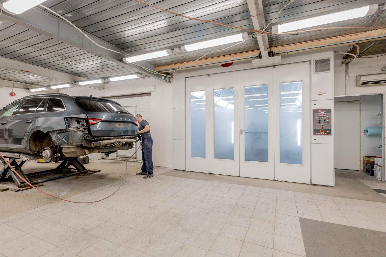 Funilaria automotiva: veículo elevado em oficina para reparo estrutural