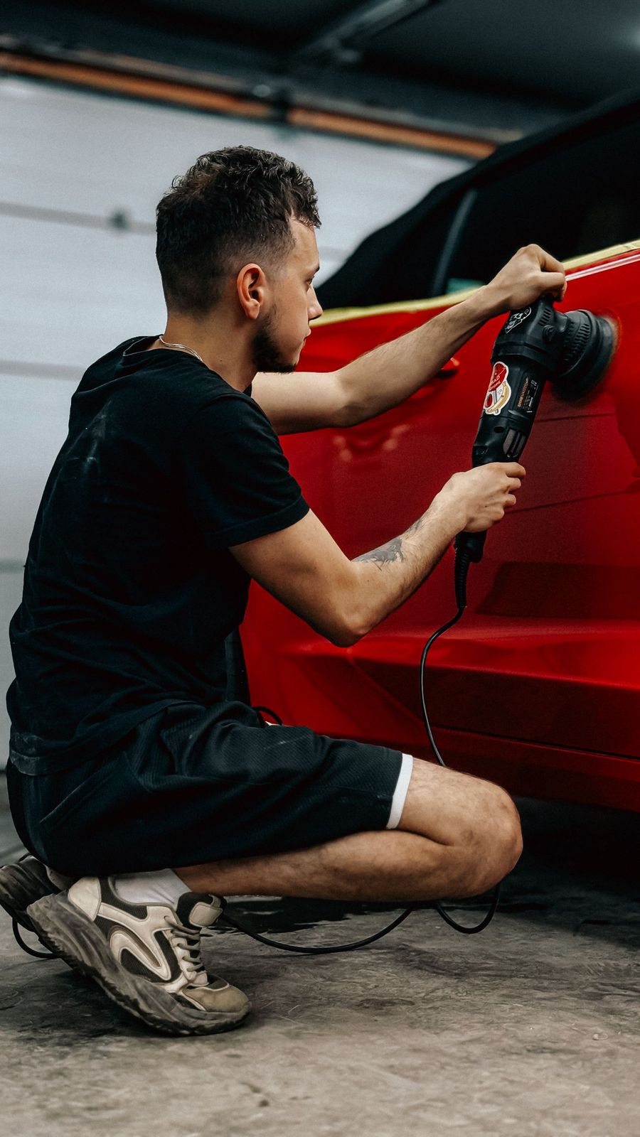 Profissional polindo carro vermelho com politriz